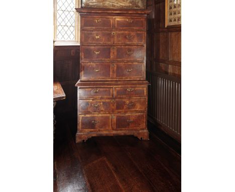 A GEORGE I WALNUT TALLBOY crossbanded and inlaid with herringbone banding throughout, the upper section with a moulded cornic