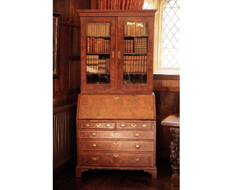 A GEORGE I WALNUT BUREAU BOOKCASE, basically circa 1720, with a moulded cornice over a pair of rectangular glazed doors enclo