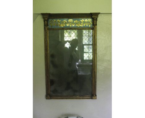 A REGENCY PIER MIRROR of architectural form, the pediment with a blue and gilt verre eglomise panel decorated with a fruiting