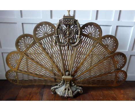 A LATE VICTORIAN GILT BRASS "PEACOCK FAN" FIRESCREEN with pierced and chased decoration, 38" wide