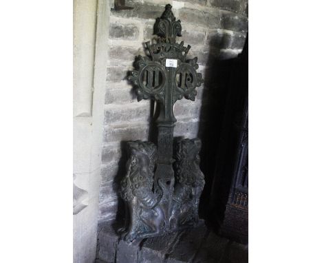 A CAST IRON ANDIRON in the manner of AWN Pugin, designed as two heraldic lions sitting back to back and supporting an upright