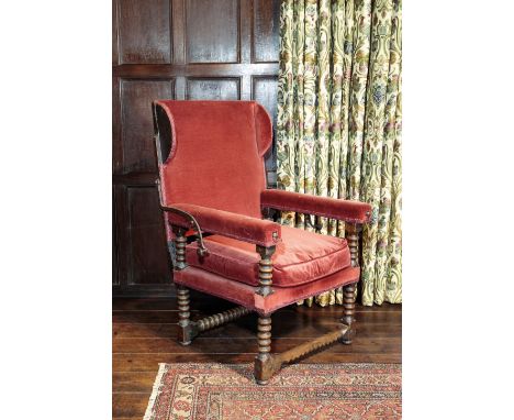 A RARE CHARLES II WALNUT SLEEPING CHAIR circa 1675, with an adjustable back with ears over padded arms on "bobbin"-turned sup