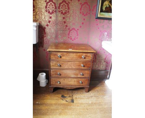 A GEORGE III STYLE MINIATURE MAHOGANY CHEST OF DRAWERS, the rectangular top over four graduated drawers, on shaped bracket fe