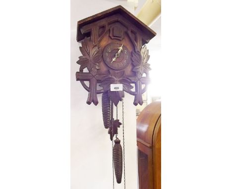 A cuckoo clock with carved vine decoration