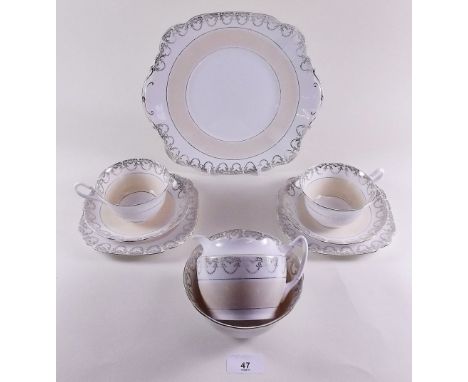 A Royal Stafford tea service in cream and gilt comprising: six cups and saucers, six tea plates, cake plate, milk and sugar 