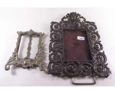 A Victorian brass scrollwork easel frame 40cm tall, with female surmount mask and a later brass frame 22cm tall
