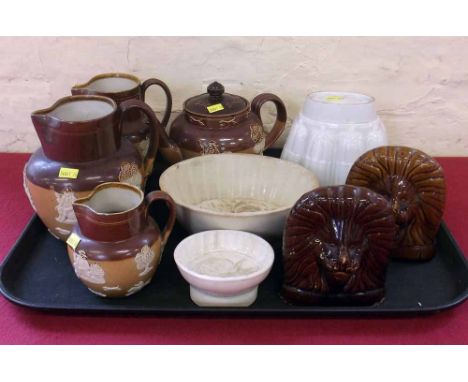 Graduated set of Doulton stoneware jugs, a teapot, also a pair of Lion window stops and three jelly moulds. Condition report: