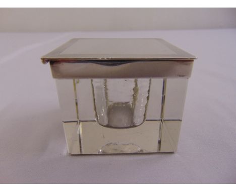 A square glass inkwell with silver engine turned cover