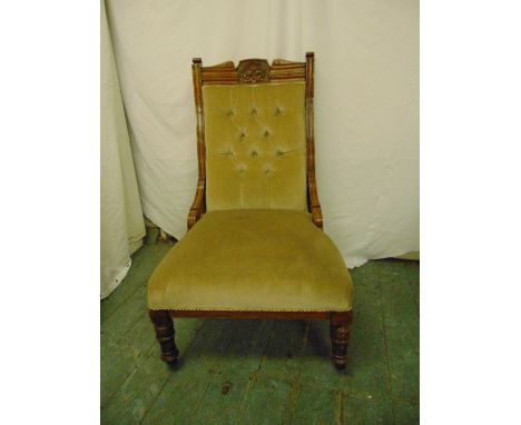 A Victorian mahogany upholstered button back chair on turned legs and original castors