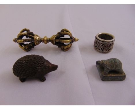 A Chinese white metal archers ring, a figurine of a hedgehog, a seal with turtle figurine and a Tibetan prayer stick