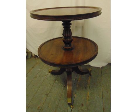 A 19th century circular mahogany two tier dumb waiter trolley on tripod feet with brass caps and castors