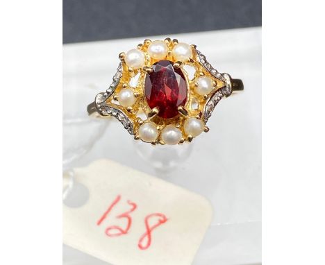 A antique garnet pearl and diamond halo ring set in gold