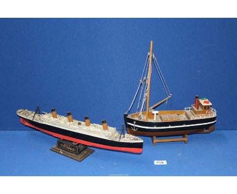 A hobby papier mache model of 'R.M.S Titanic' and a wooden model of a fishing boat.