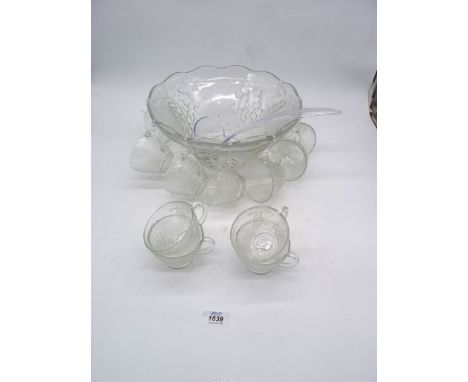 A glass Punch Bowl having grape vine design with 12 glasses and a ladle.
