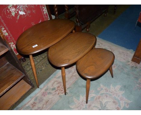 A nest of three Ercol Elm pebble shaped topped Occasional Tables, each standing on three turned legs, the largest 25 1/2'' x 