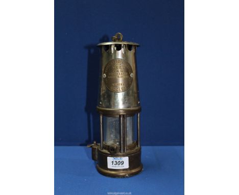 A miner's/Davy Lamp by the Protector Lamp & Lighting Co. Ltd., Eccles with a manufacturer's label indicating that it is a "Ty