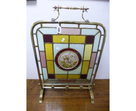A BRASS FRAMED FIRESCREEN, with multi coloured glass panels, the central circular panel with floral design (sd)
