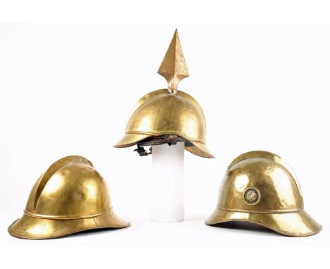 Fireman's helmets. Three brass fireman's helmets, the crowns with combs, the brims with rolled edges. Two examples with liner