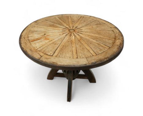 Indian cartwheel style table, the revolving top with quarter veneered hardwood panels and iron rim edge above a wheel hub bas