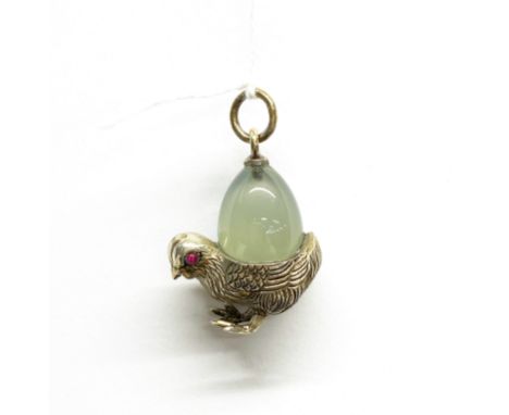 A white metal and polished jade chick pendant (tested silver) with ruby eyes, probably Russian, H. 3.5cm.
