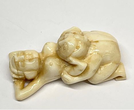 A Japanese carved erotic bone netsuke, L. 5.5cm.