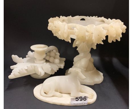 A 19th century carved alabaster model of a greyhound, H. 15cm, with an alabaster candlestick and comport.