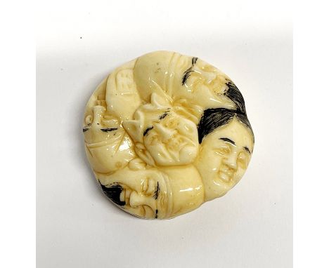 A Japanese carved bone circular amulet/toggle, dia. 4cm.