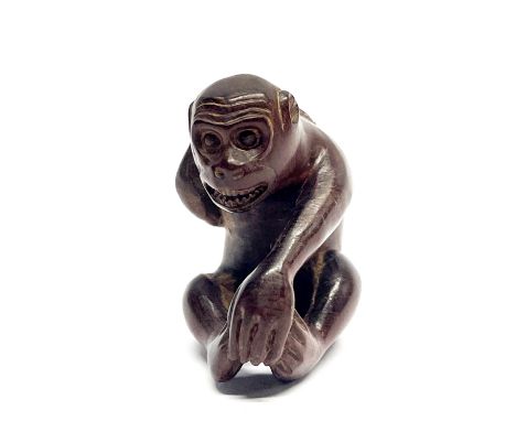 A signed carved fruitwood netsuke of a monkey, H. 5cm.