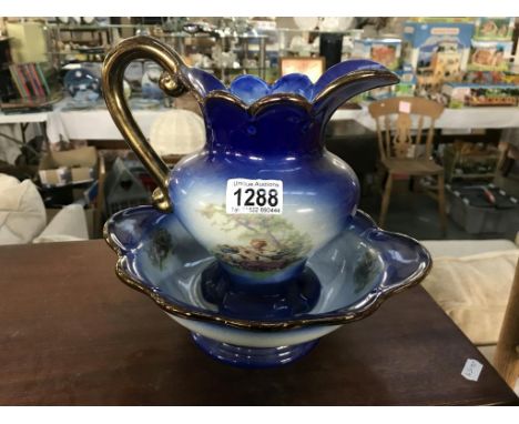 A flow pottery basin &amp; jug with classical scene &amp; gilding to edge