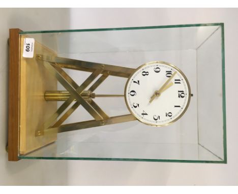 A REPRODUCTION BRASS SKELETON MYSTERY CLOCK UNDER SQUARED GLASS DOME, MOUNTED ON A LIGHTWOOD PLINTH 