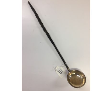 A GEORGIAN WINE TASTING LADLE WITH WHALE BONE HANDLE AND WHITE METAL BOWL