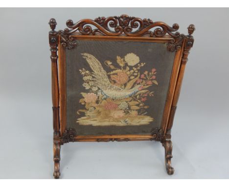 Victorian rosewood firescreen, the square frame with tapestry panel carved top rail and corners between turned supports on sh