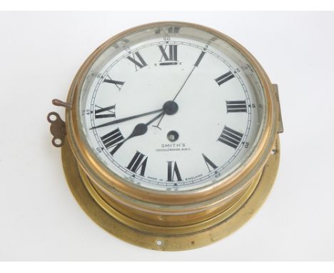 A good vintage Smiths brass cased wall mounted marine clock with Roman chapters on a white dial face, 17cm dia. 