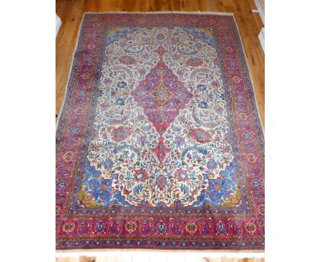 Sarouk carpet, of traditional foliate design with central tear drop medallion to centre over ivory ground, red ground corresp