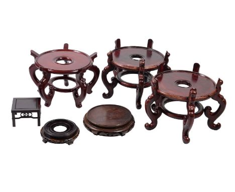 Six various Chinese wood stands, 20th century, comprising a large circular pair supported on five scroll feet, 31cm high x 31