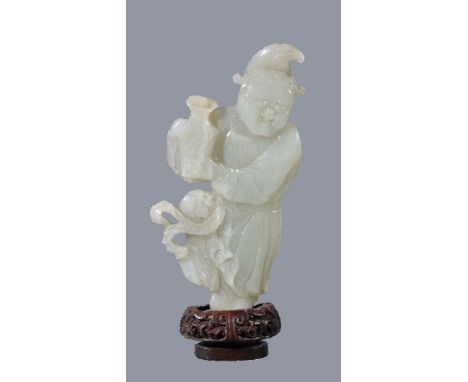 A Chinese celadon jade figure of a ‘Foreigner’, standing holding a vase, the jade 13cm high, glued to wood base and overall h