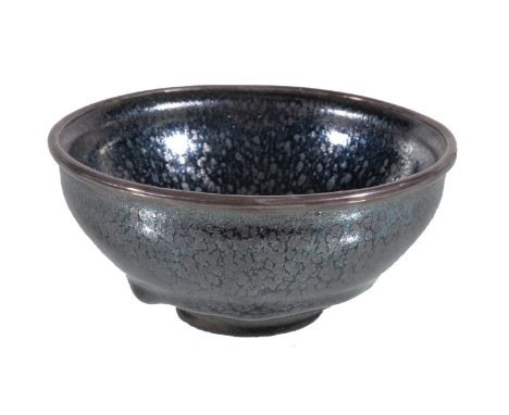A Chinese Jian type 'oil-spot' tea bowl, heavily potted, the rounded sides rising from a short foot to a slightly everted met