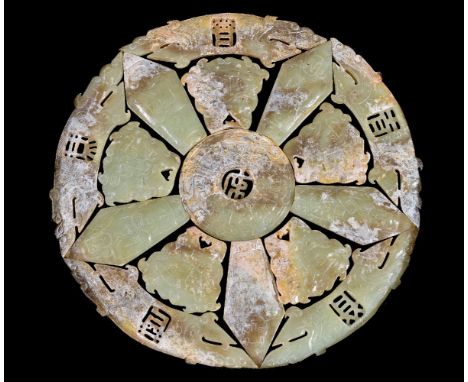 A Chinese celadon white and brown jade archaistic sectional roundel, overall diameter 22cm, fitted box
