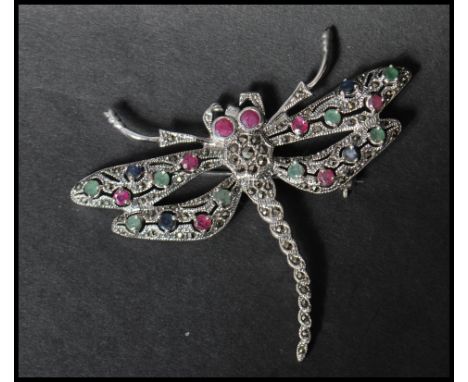 A 925 silver figural brooch in the form of&nbsp; a dragon fly set with marcasite with green and red accent stones, having a r