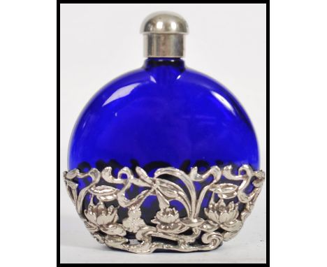 A silver and blue glass ladies perfume bottle flask. Of moon shaped form with pierced silver embellished base. Weight 152.5g 