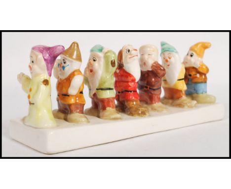 A vintage 20th century Snow White and he Seven Dwarfs ceramic toast rack.&nbsp;Measures 20cm long.&nbsp;