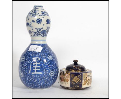 An Oriental Chinese ceramic double gourd vase of traditional blue and white form along with a Japanese Satsuma pot depicting 