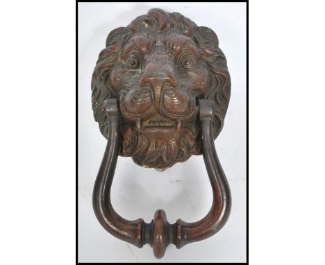 An early 20th century cast iron lion mask door knocker with remnants of original paint. Measures 20 cm long.