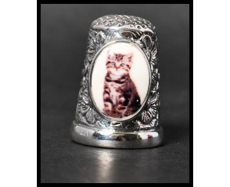 A 925 silver thimble with an enamel painted plaque depicting a cat. Marked 925. Weight 12.5g. Measures approx 2.5cms.