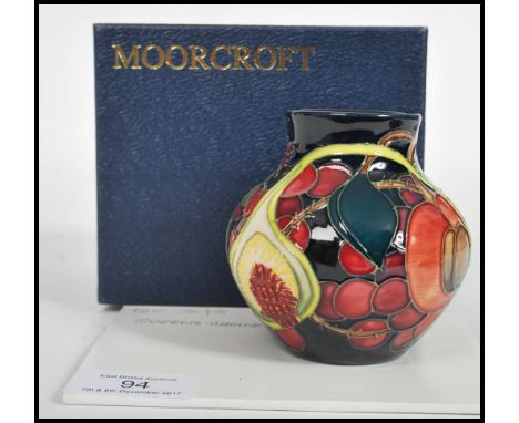 A Moorcroft ceramic vase tube lined decorated with flowers in the Queens Choice pattern complete in original box C2000 scisso