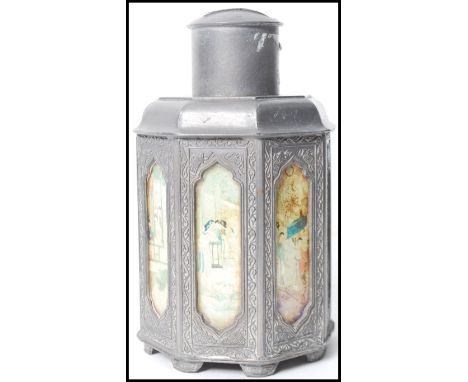 An early 20th century Chinese tea caddy having a sloped pewter body and lid with various inset panels depicting domestic scen