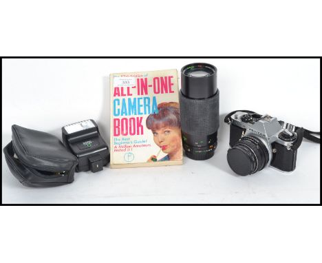 A vintage 20th century Pentax camera with a Sirus lens and flash along with an All in one camera book.