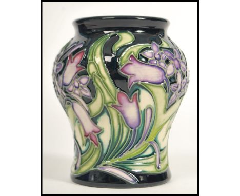 A Moorcroft ceramic vase tube lined decorated with flowers in the Isis pattern complete in original box C2000 scissor marks a