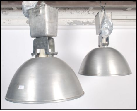 A pair of large industrial vintage mid 20th century aluminium ceiling lights of domed circular down lighter form, each with i
