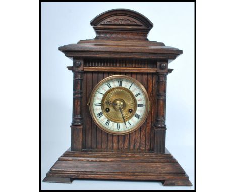 A vintage 20th century HAC wooden cased mantle clock having a columned hood. The enamel face having faceted hands. Measures 4